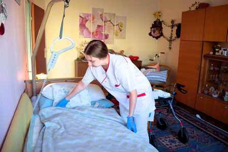 Eine Johanniterin macht das Bett einer Klientin.