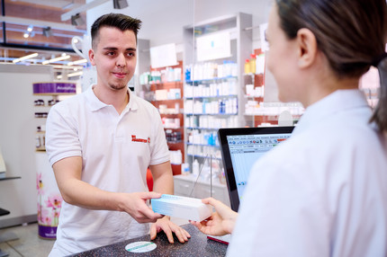 Ein Johanniter vom Medikamentenmanagement nimmt von einer Apothekerin Medikamente entgegen