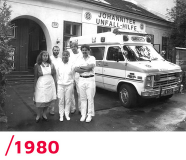 1980: Sechs Johanniter neben einem Einsatzauto vor der ersten Rettungsstation in Wien.