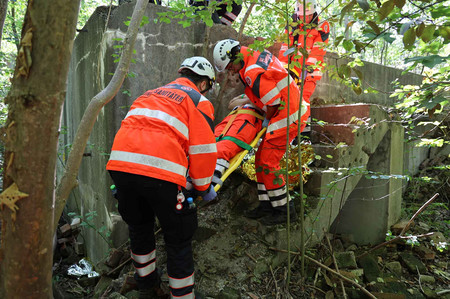 Drei Johanniter bergen bei einer Übung eine Person aus unwegsamen Gelände.