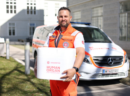 Ein Johanniter hält eine Transportbox mit einem Spenderorgan in der Hand.