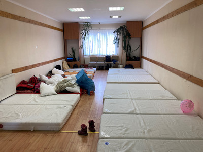 Ein Raum mit vielen nebeneinander aufgelegten Matratzen, wo ankommende Leute sich erholen können.
