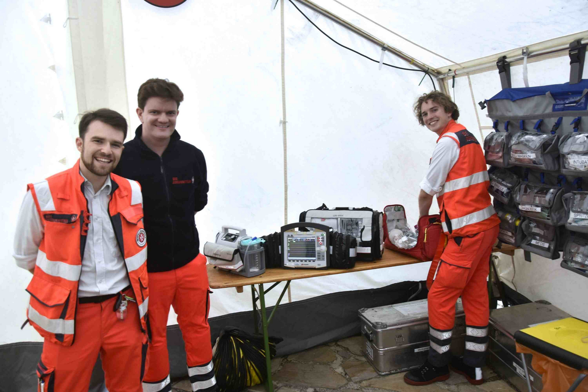 Drei Sanitäter bei Vorbereitungen im Sanitätszelt