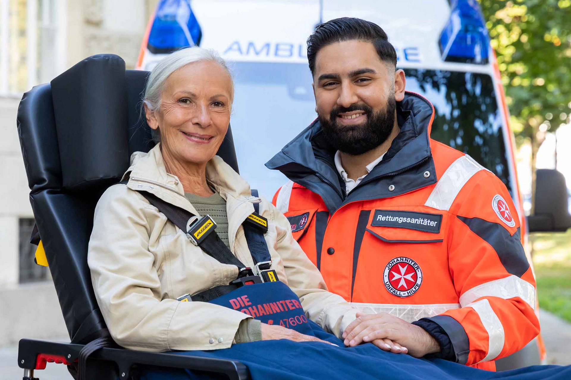 Eine Patientin auf einer Fahrtrage und ein Zivildienstleistender, der ihre Hand hält