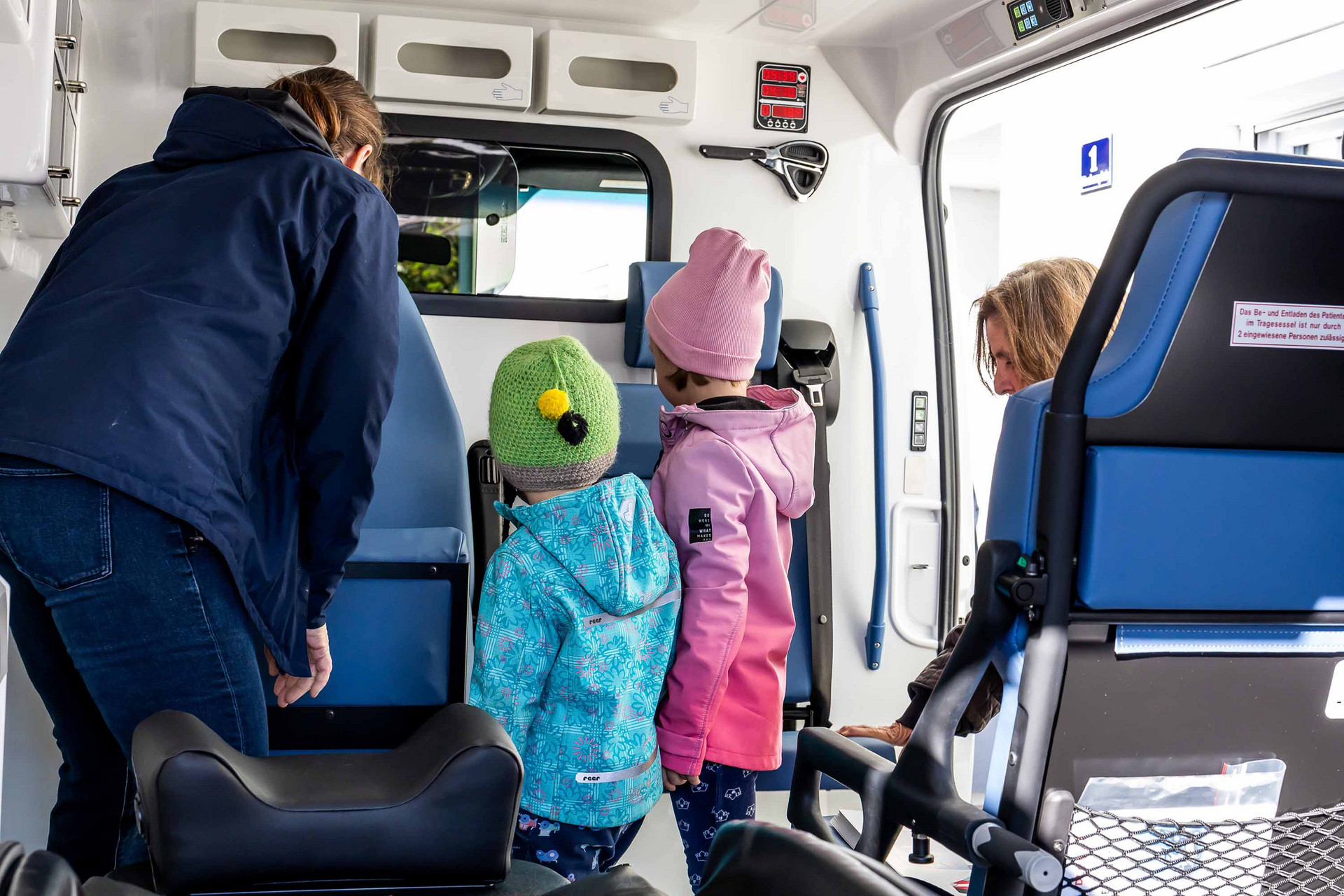 Kinder erkunden das Rettungsauto der Johanniter.