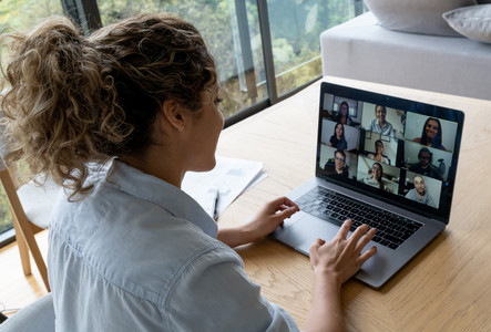 Eine Frau sitzt vor ihrem Laptop und ist in einer Videokonferenz.