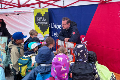 Ein Johanniter zeigt Schulkindern den Erste-Hilfe-Koffer.