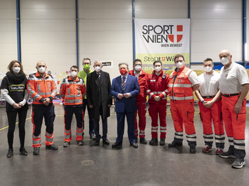 Bundespräsident Van der Bellen und Bürgermeister Ludwig mit Mitarbeiter:innen von Train of Hope, den Johannitern und dem Roten Kreuz.