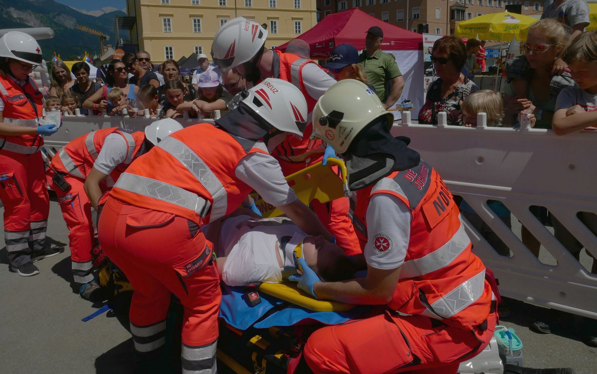 Rettungssanitäter:innen zeiogen während einer Übungsschau wie sie eine verletzte Person auf einer Fahrtrage erstversorgen.