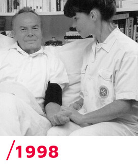 1998: Eine Johanniterin vom Akutpflegedienst misst bei einem Patienten den Blutdruck.