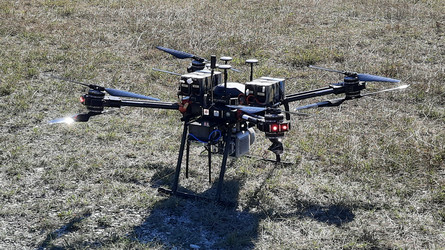 Eine Drohne am Versuchsgelände, einer großen Wiese