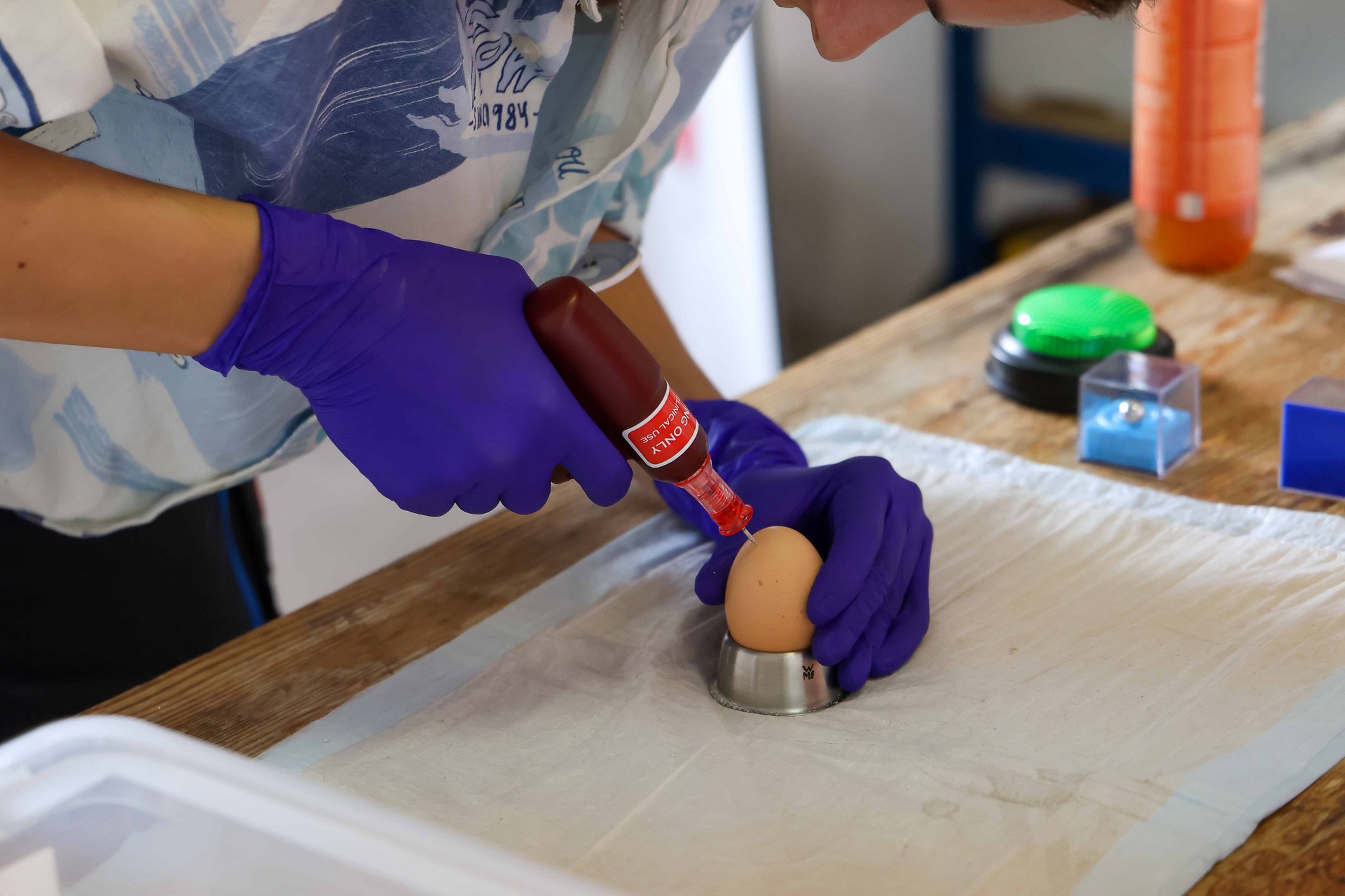 Mit einem Bohrer werden Löcher in ein rohes Ei gebohrt.