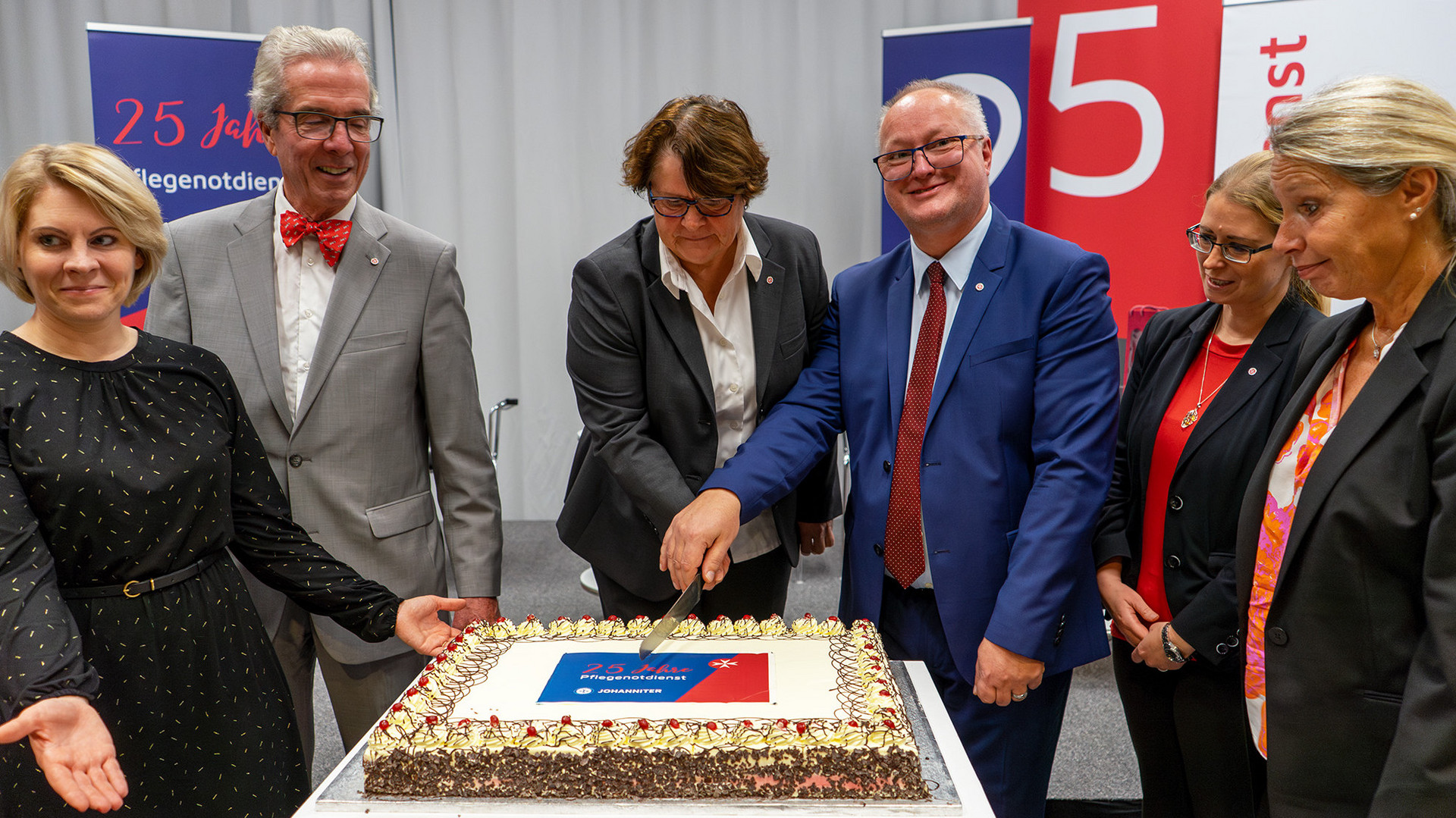 Vertreter:innen der Johanniter und des FSWs schneiden die Torte an.