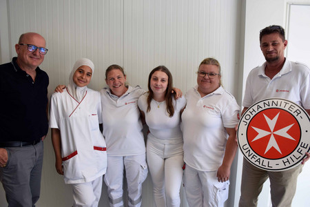 Die vier Teilnehmerinnen des Pflegeaustauschs gemeinsam mit 2 österreichischen Johannitern lächeln in die Kamera.