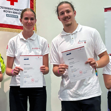 Zwei Jugendliche halten stolz ihre Urkunde mit der Gold-Auszeichnung im Landesjugendbewerb.