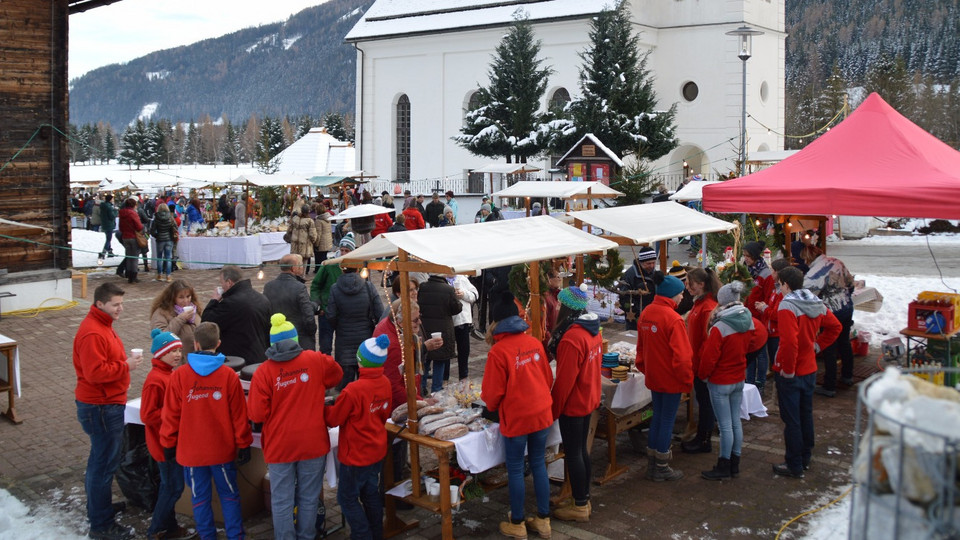 Viele Beuscher bei den Ständen des Christkindlmarktes. Die Johanniter-Jugend hilft an mehreren Ständen beim Verkauf mit.