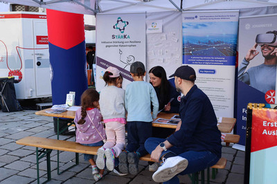 Eine Johanniterin der Forschung erklärt den Kindern anhand von entwickelten Spielen die Forschungsprojekte.