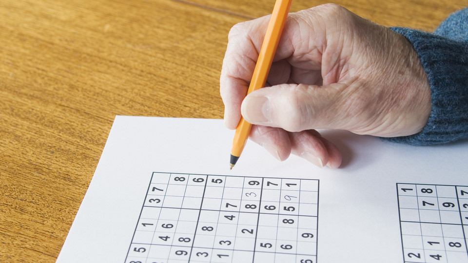 Jemand löst ein Sudoku.