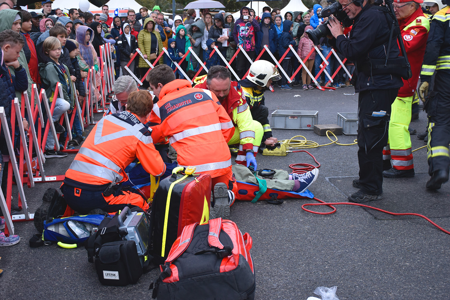 Ein Johanniter und andere Einsatzkräfte der Rettung und Feuerwehr versorgen bei einer Einsatzvorführung eine Patientin.